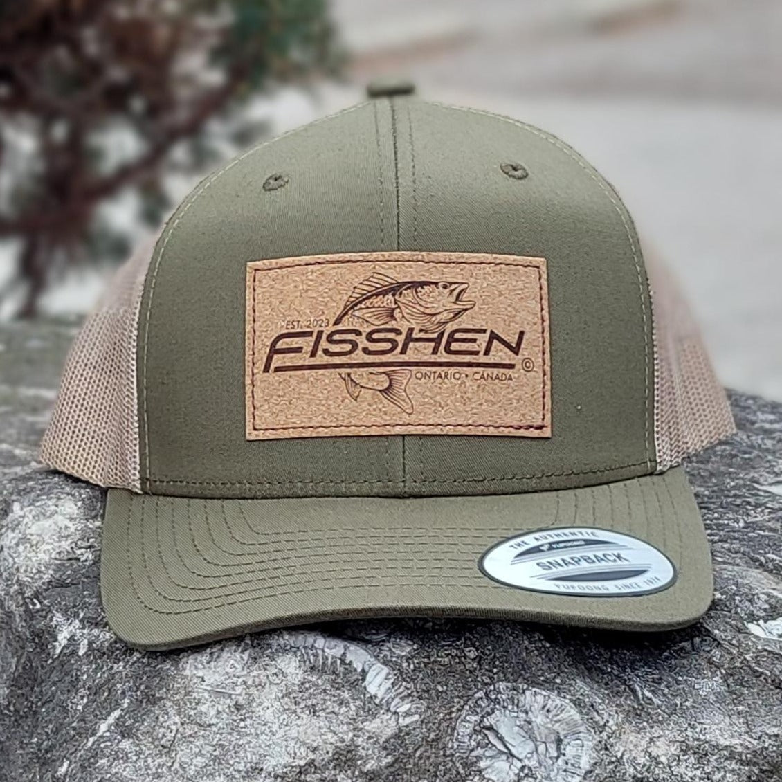 Fishing design with the word Fisshen. Trout image on a cork patch. Hat is Moss green with taupe back