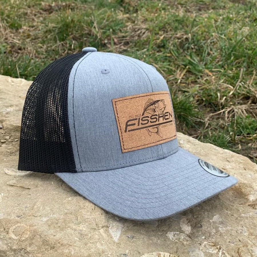 Fishing design with the word Fisshen. Trout image on a cork patch. Hat is gray front with black back