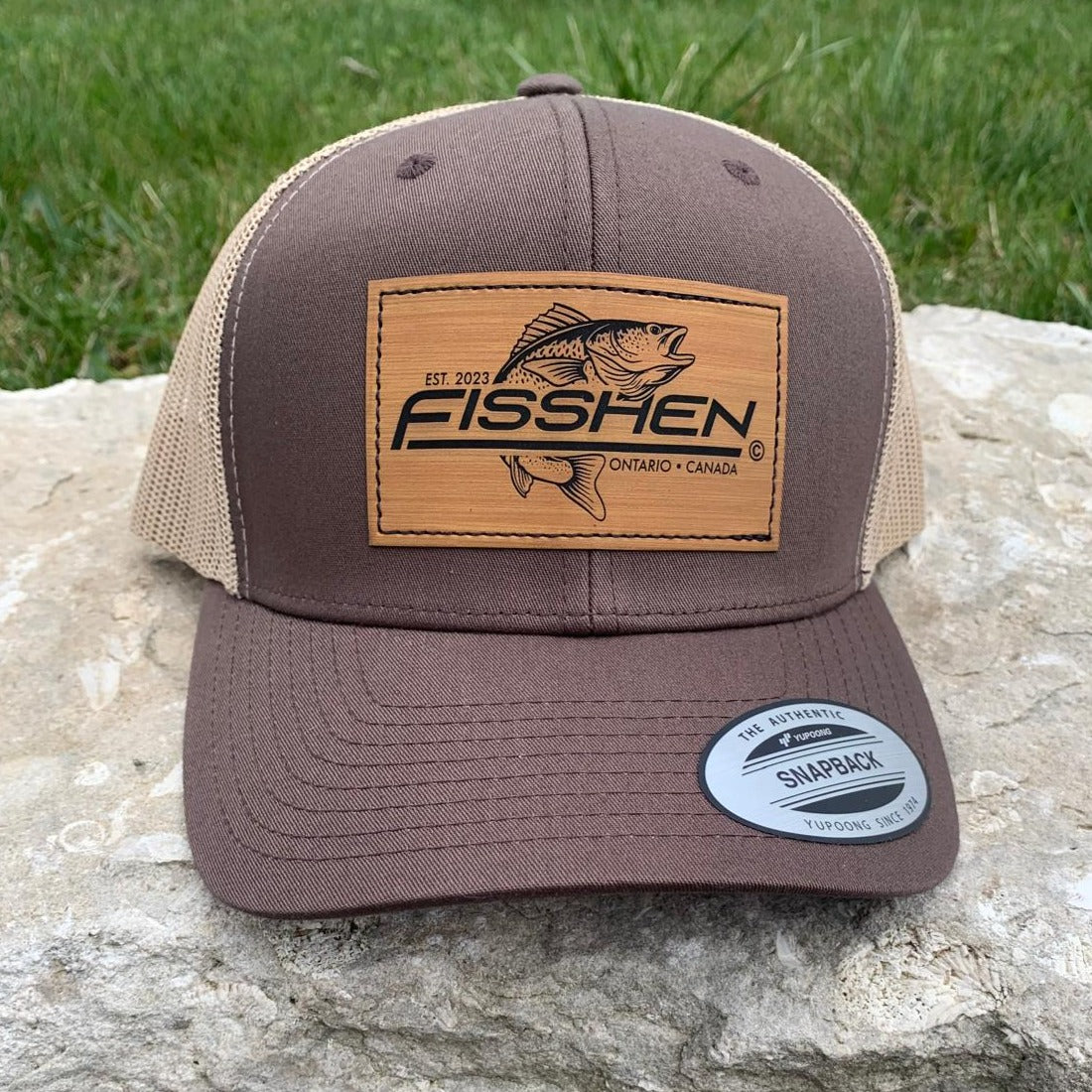 Fishing design with the word Fisshen. Trout image on bamboo patch. Hat is Brown with a taupe back
